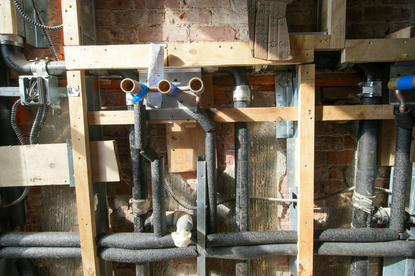 Plumbing rough-in with water and drain lines in an open wall